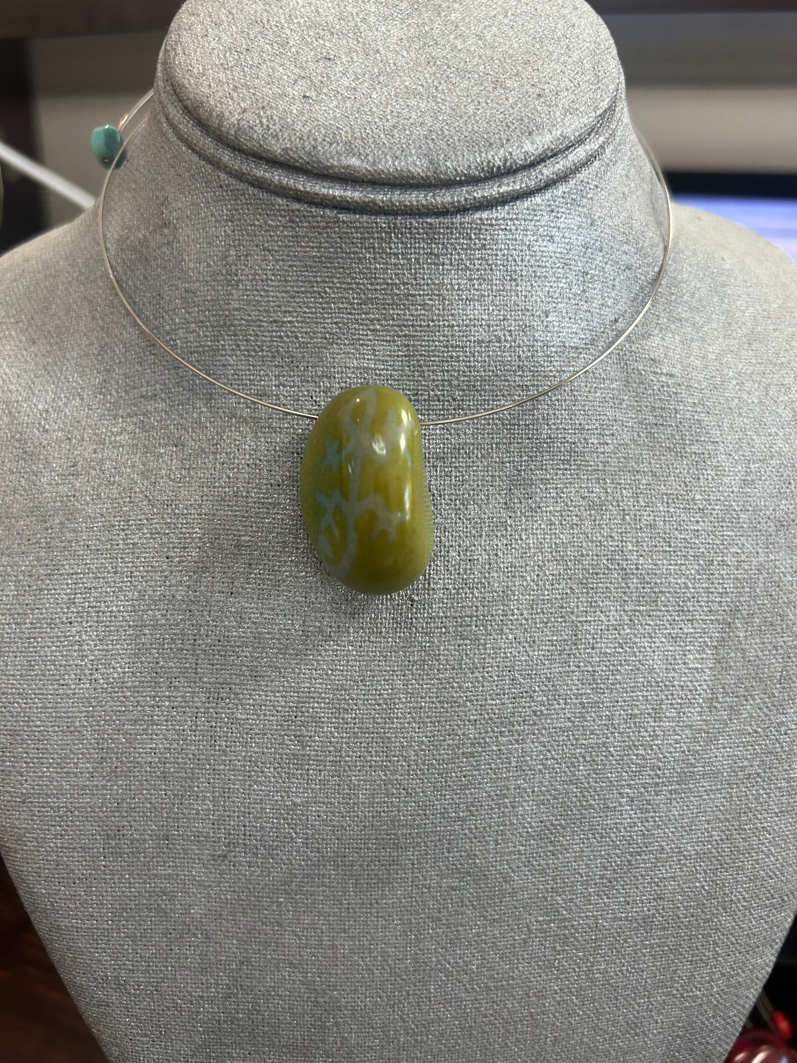 Collar con dije de piedra pulida en tono verde oliva con delicados detalles en azul