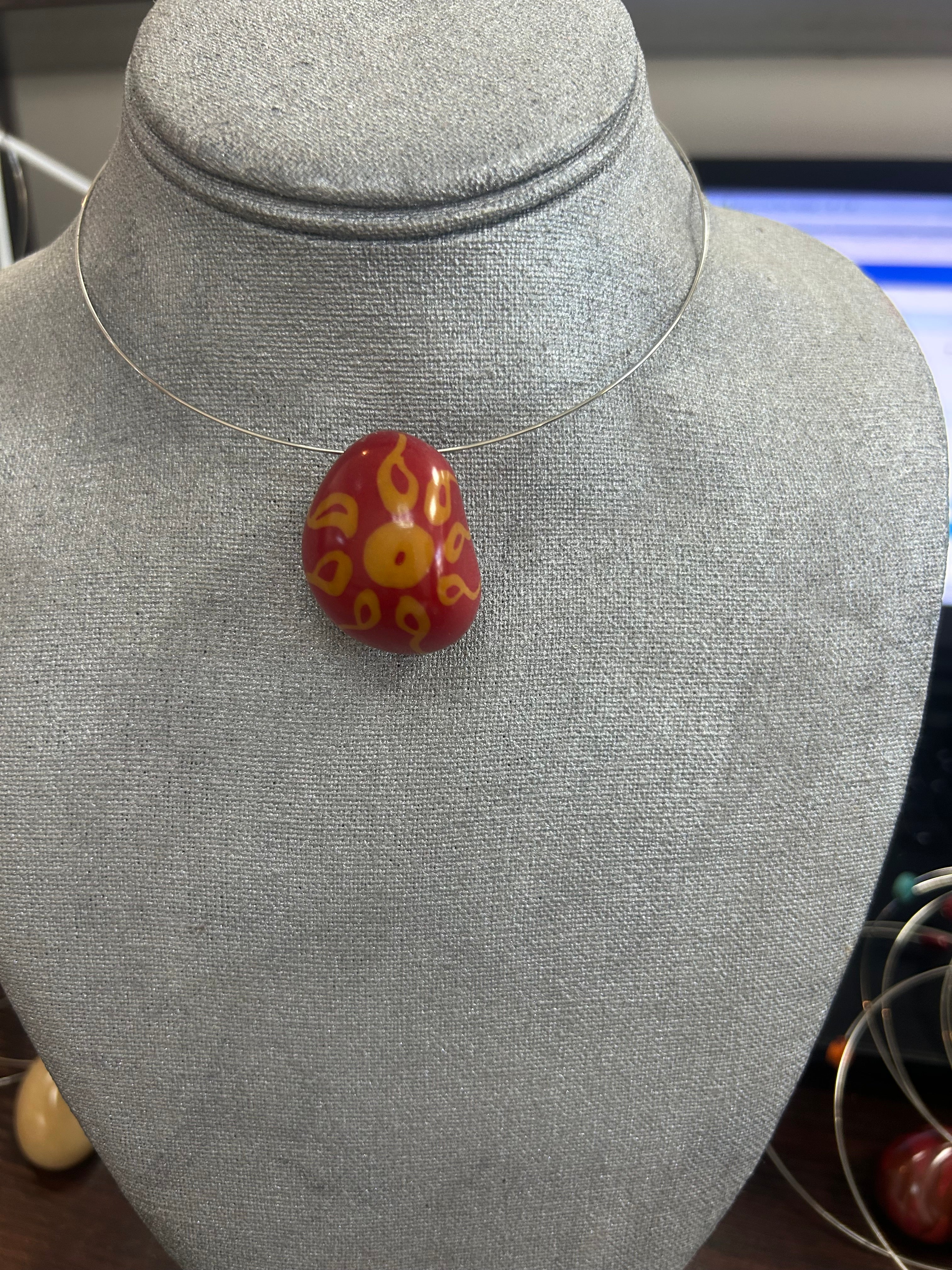 Collar con dije de piedra pulida en rojo vibrante con diseño artesanal en tonos dorados