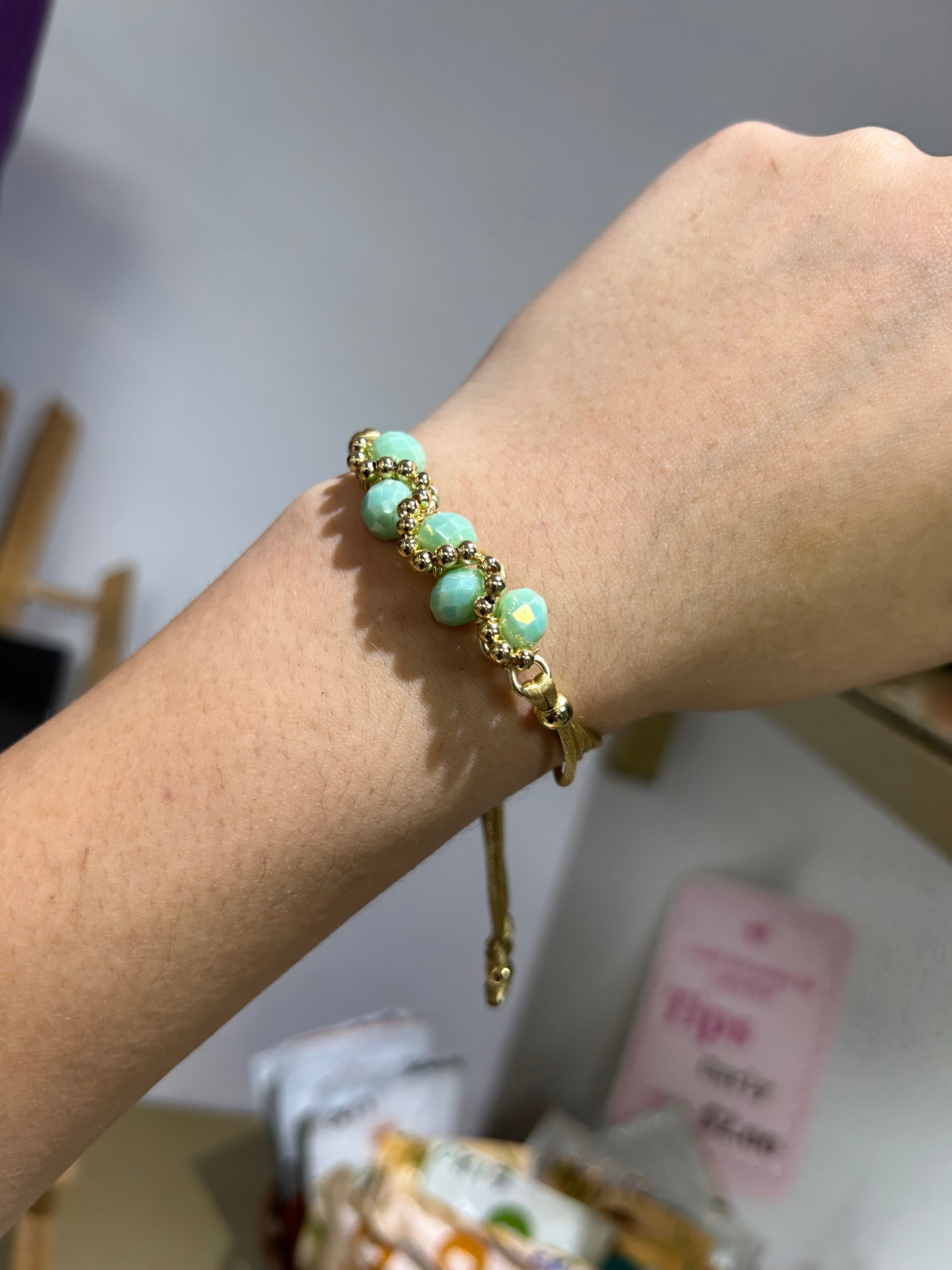 Pulsera de hilo dorado con piedras celestes
